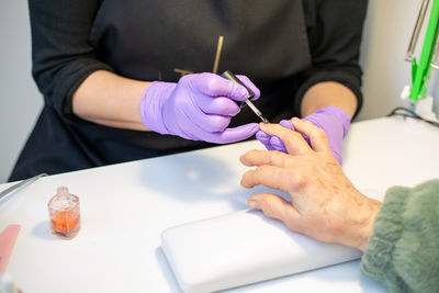 Midsection of man writing in book