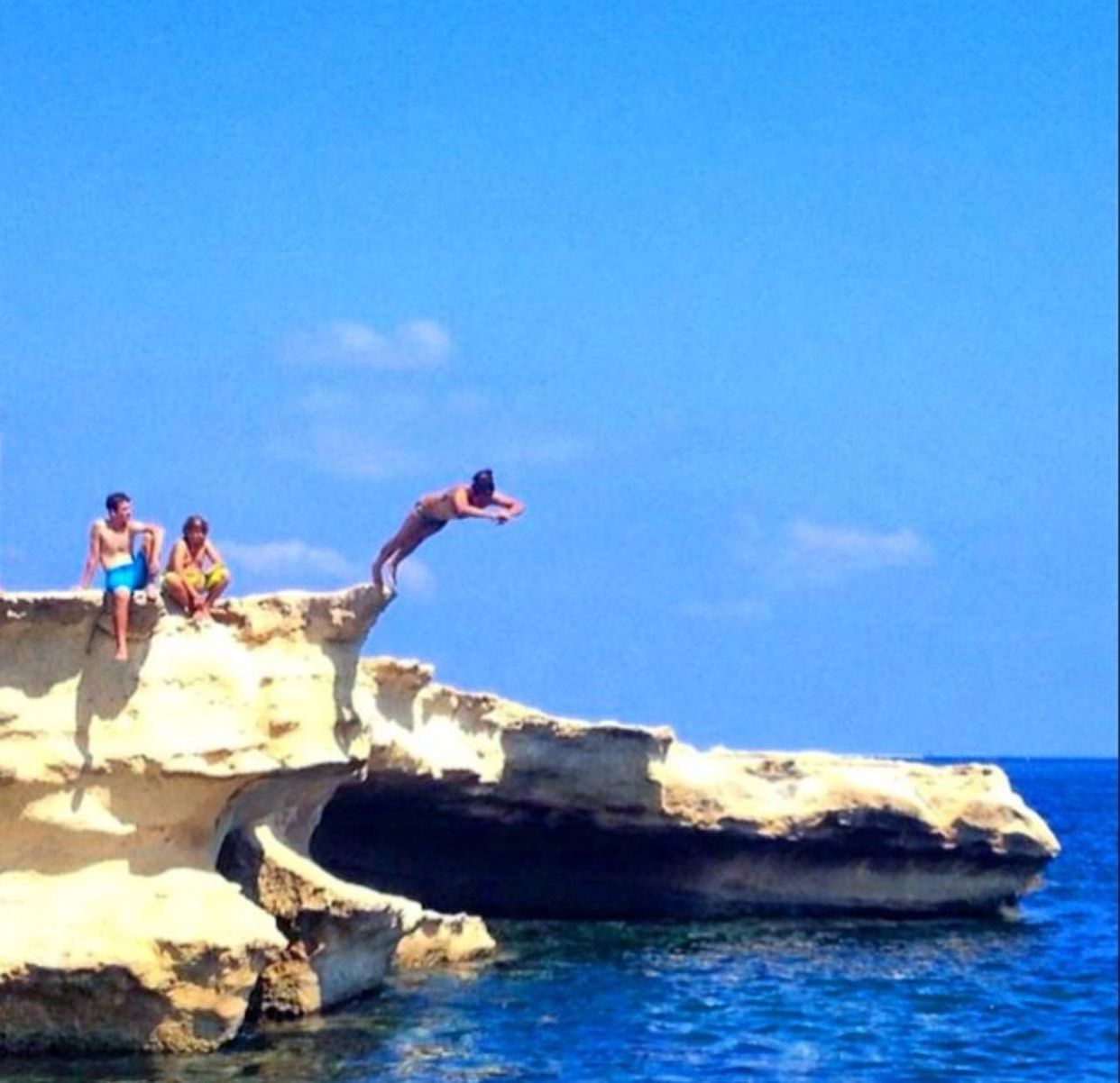 sea, water, rock - object, blue, leisure activity, lifestyles, clear sky, rock formation, men, sky, copy space, horizon over water, beach, rock, vacations, nature, full length, scenics