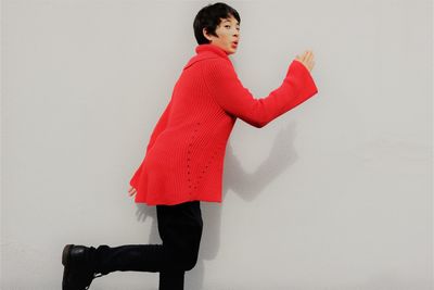 Side view of woman standing against white background