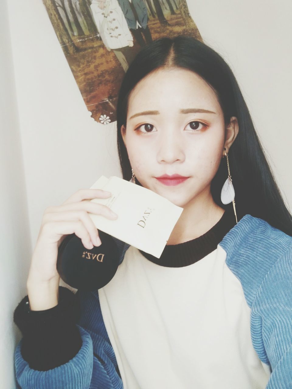 CLOSE-UP PORTRAIT OF A SMILING YOUNG WOMAN HOLDING PAPER