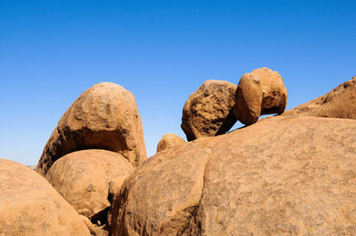 Rocks in desert against clear blue sky
