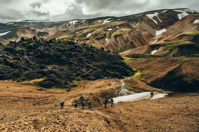 People on mountain against sky