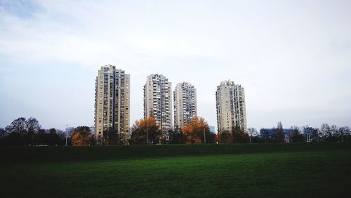 View of skyscrapers in field against sky
