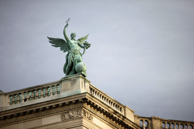 Low angle view of angel statue against sky at hofburg palace