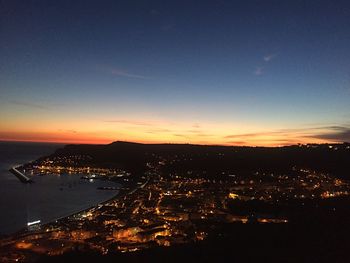 High angle view of illuminated cityscape against sky at dusk