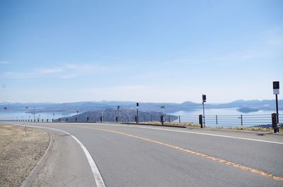 Road by mountains against sky