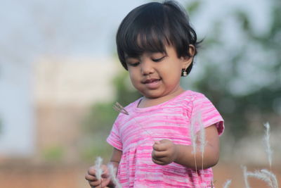 Portrait of cute girl holding outdoors