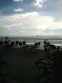 Deck chairs on beach against sky