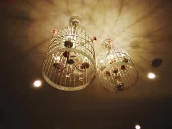 Low angle view of illuminated chandelier hanging on ceiling