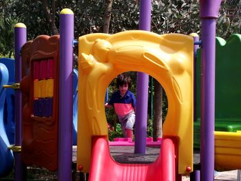 Boy in play equipment at park