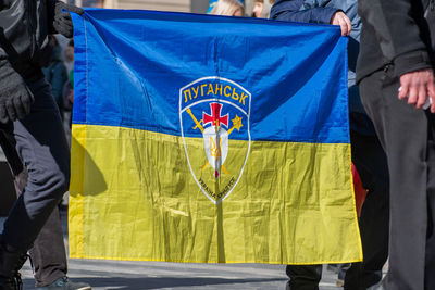 Flag of ukraine above all with symbol or logo of luhansk or lugansk city near the border with russia