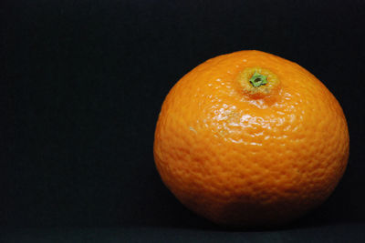 Close-up of orange apple on black background