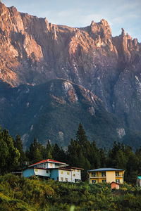 Houses by mountains against sky