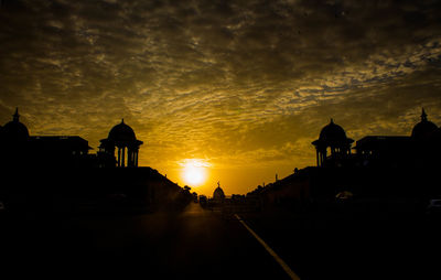 Silhouette city against sky during sunset