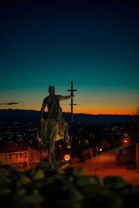 Rear view of man standing against clear sky during sunset