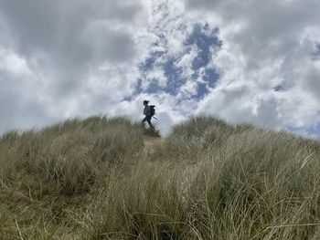 Man standing on field against sky