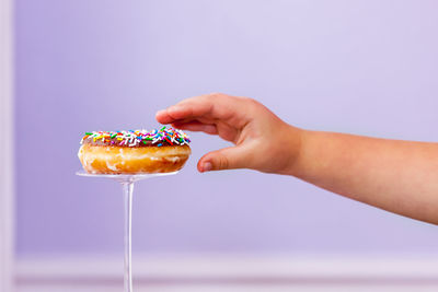 Close-up of hand reaching for donut