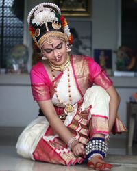 Full length of a smiling young woman sitting outdoors