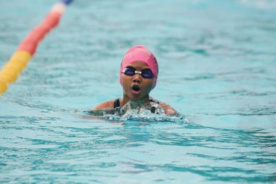 Portrait of smiling young woman swimming in pool