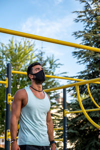 Young man wearing mask exercising outdoors