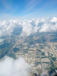 Aerial view of cityscape against cloudy sky