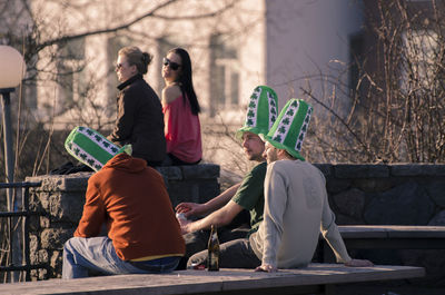 Rear view of people sitting on bench