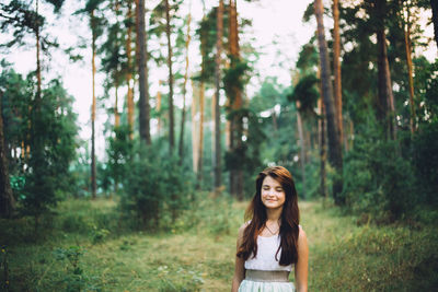 Portrait of smiling young woman in forest