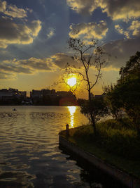 Scenic view of river against sky at sunset