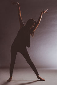 Low angle view of woman dancing against white background