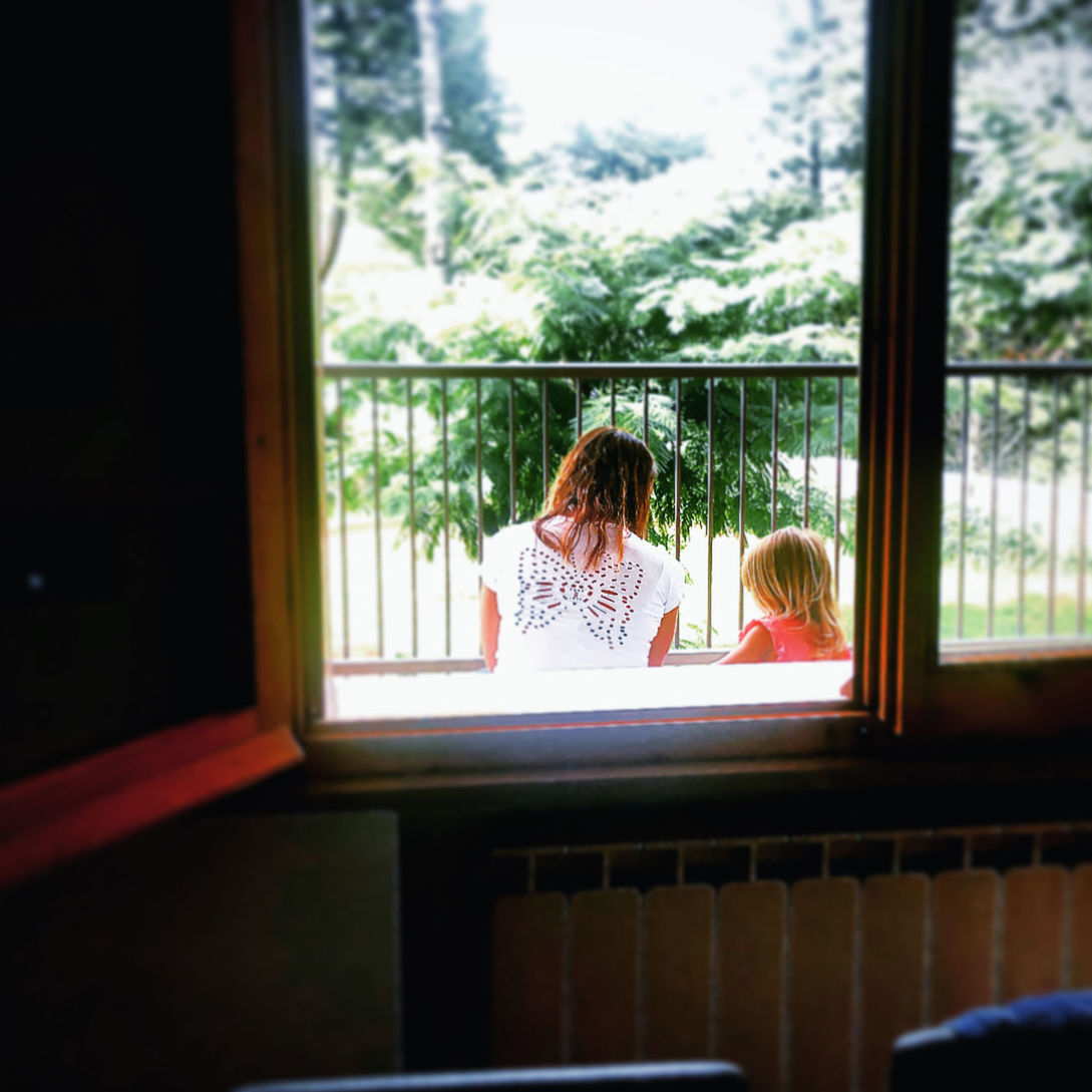 WOMAN SITTING IN WINDOW