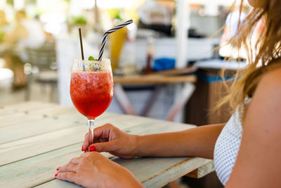 Midsection of woman holding fruit on table