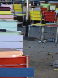 Empty chairs and tables at sidewalk cafe