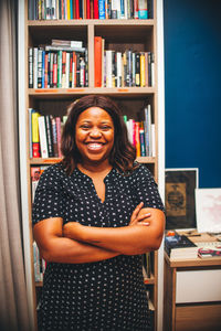 Portrait of smiling young woman standing in library