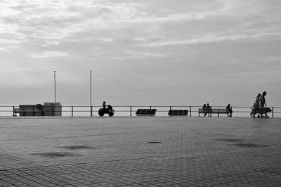 People on promenade against sky during sunset