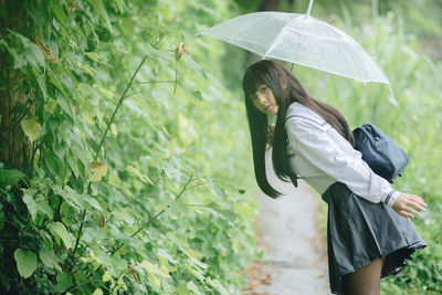 Woman standing on plant during rainy season