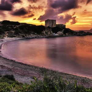 Scenic view of sea against dramatic sky during sunset