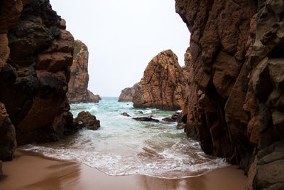 Rocks on beach against sky