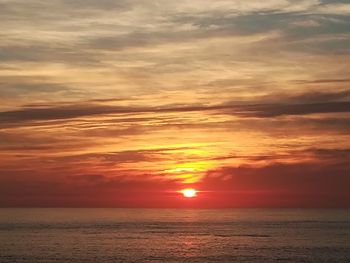 Scenic view of sea against romantic sky at sunset