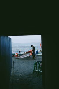 People on boat in sea against sky