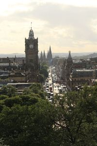 View of buildings in city against cloudy sky