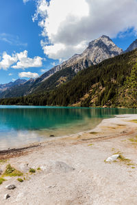 Scenic view of lake by mountains against sky