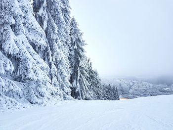 Snow covered landscape against clear sky