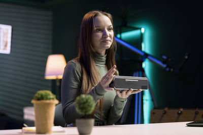 Young woman using mobile phone at table