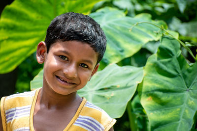 The portrait of a beautiful serene indian child in the background of a dark green forest