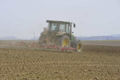 Tractor on agricultural field against sky