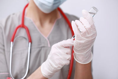 Midsection of doctor holding dentures in laboratory