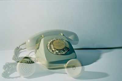 Double exposure of old telephone on table