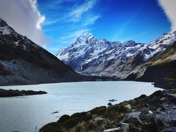 Scenic view of lake by mountains against sky