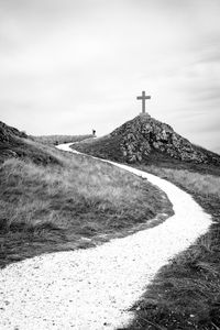 View of cross on field against sky