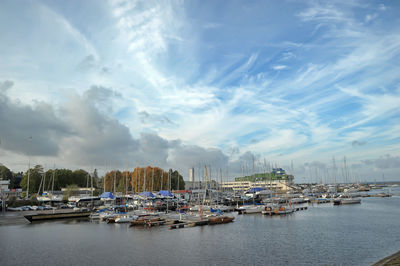 Sailboats moored at harbor against sky